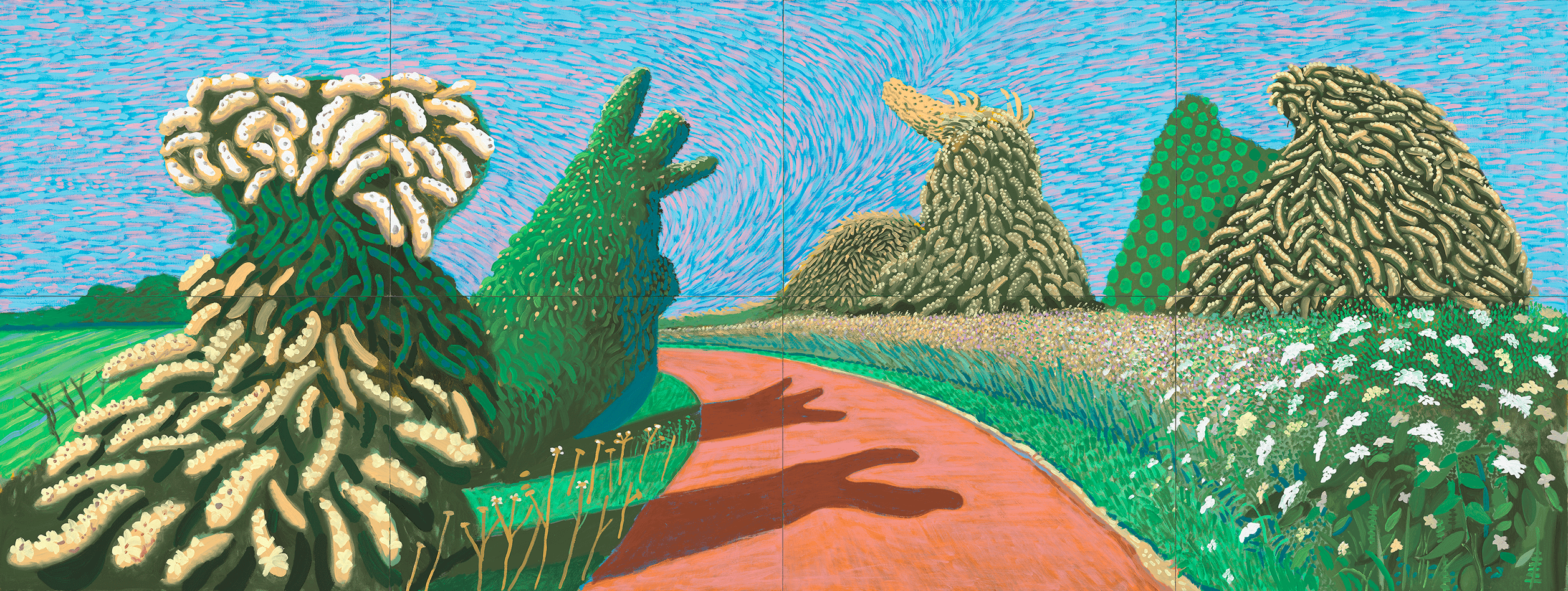 A colourful, surreal landscape with a winding red path, green fields, and large, bush-like shapes resembling animal figures. The sky is bright blue, filled with swirling lines, creating a lively, whimsical atmosphere.