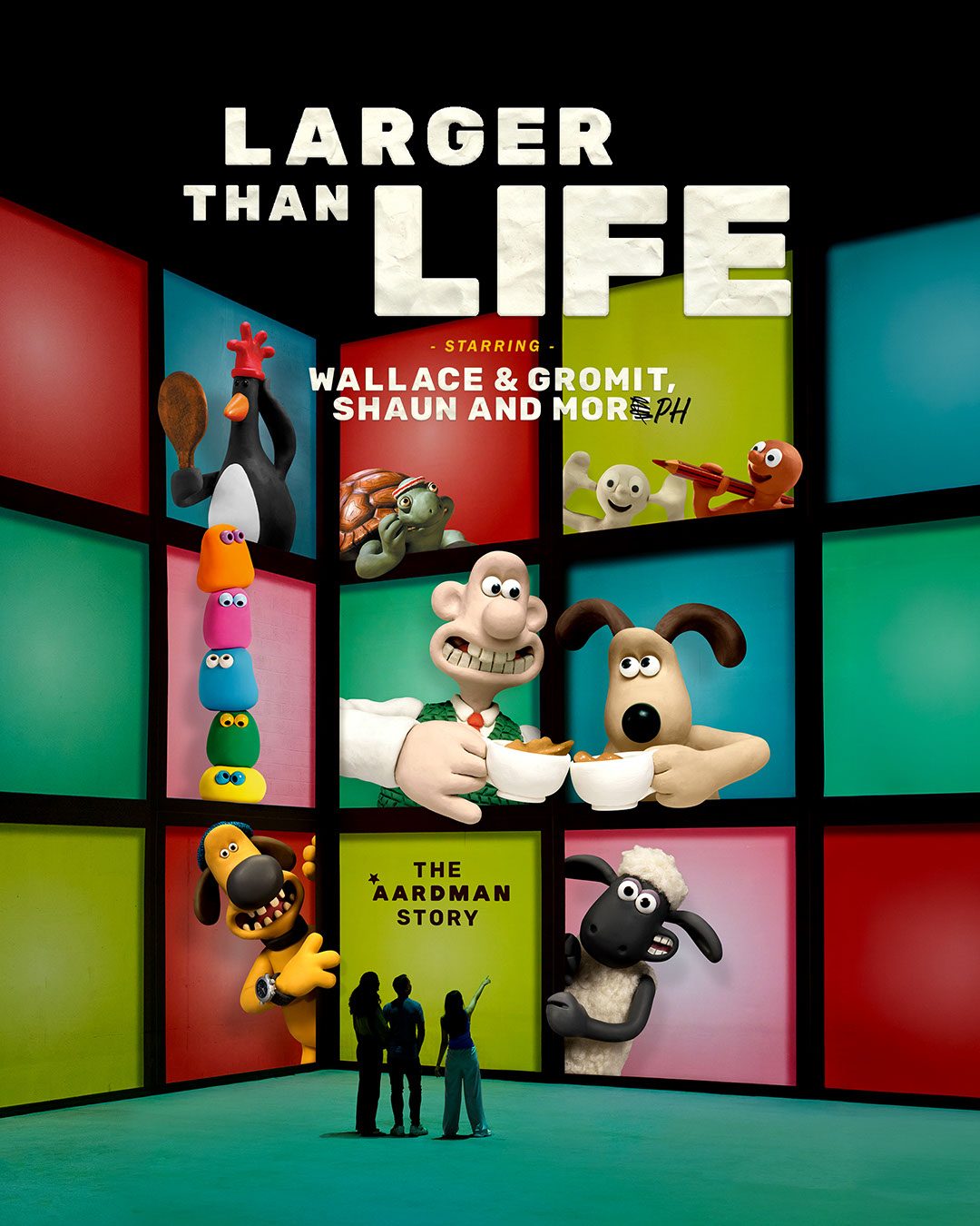 People stand in front of a colourful wall featuring characters like Wallace, Gromit, and Shaun the Sheep from Aardman animations, with bold text reading Larger Than Life: The Aardman Story.